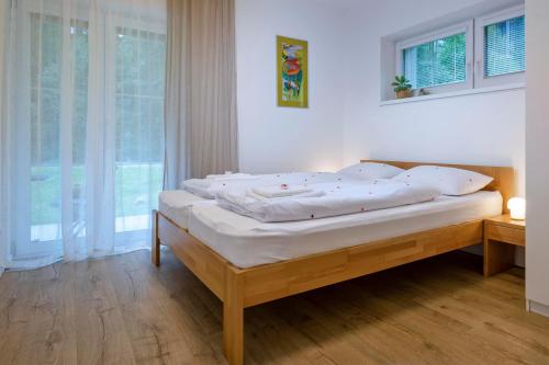 sypialnia z łóżkiem z białą pościelą i oknem w obiekcie Apartmán Vrátna w Tierchowej