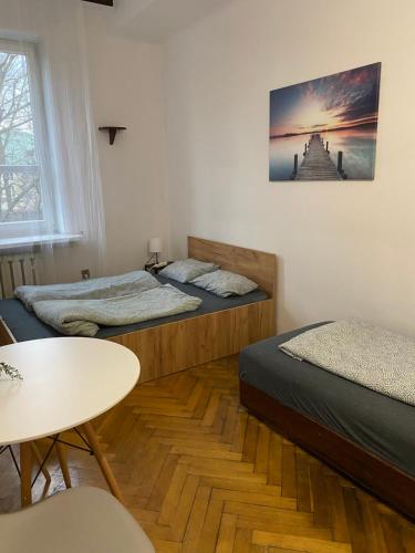 um quarto com duas camas e uma mesa em Classy Rooms in Old Town em Cracóvia