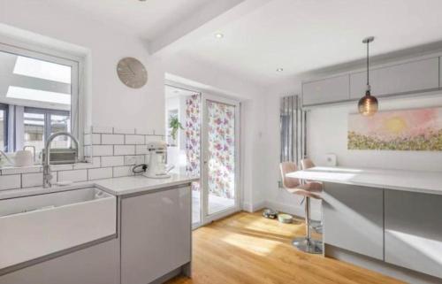 a kitchen with white counters and a sink and windows at MODERN 3 BED - Sleeps 6 with HOT TUB in Bath