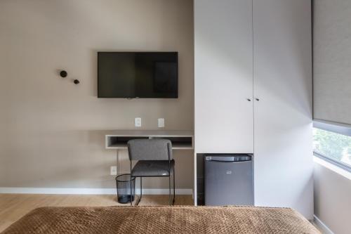 a room with a desk and a television on a wall at Bewiki in Florianópolis