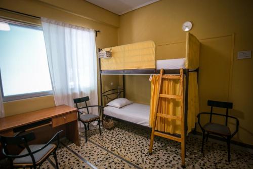 a room with two bunk beds and a desk and chairs at The Holy Rock - Hostel at meteora in Kalabaka