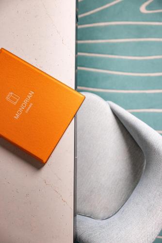 an orange book sitting on top of a chair at Mondrian Cannes in Cannes