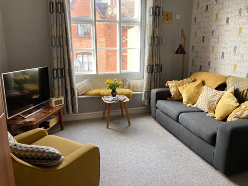 a living room with a couch and a tv at Assembly View - two bedroomed apartment with parking permit in Ludlow Town Centre in Ludlow