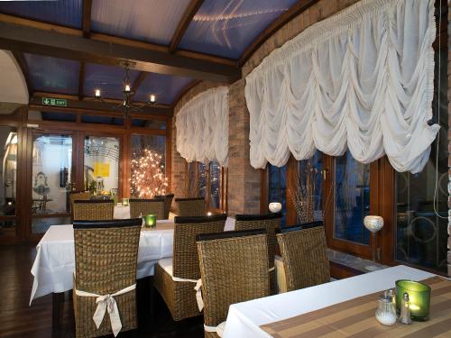 a dining room with tables and chairs and curtains at Hotel City Pisek in Písek