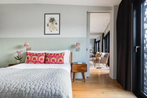 a bedroom with a bed and a living room at Town Hall Hotel - Shoreditch in London