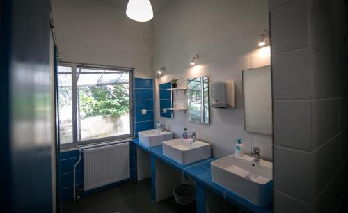 a bathroom with two sinks and a window at The Holy Rock - Hostel at meteora in Kalabaka