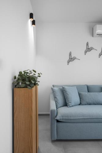 a living room with a blue couch and a plant at ROTHOS LUXURY in Stavros