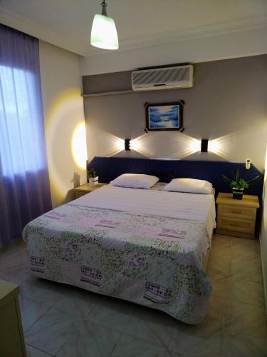 a bedroom with a large bed with a blue headboard at California Apart Otel in Oludeniz