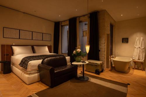 a bedroom with a bed and a bath tub and a chair at The Venice Venice Hotel in Venice