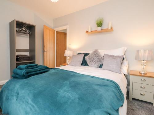 een slaapkamer met een groot bed met een blauwe deken erop bij Ferry View in Fleetwood