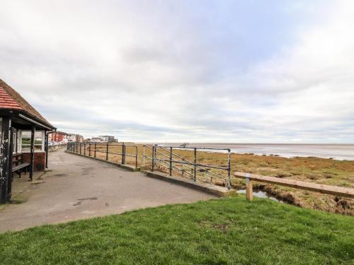 a walkway to the beach with the ocean in the background at Ferry View in Fleetwood