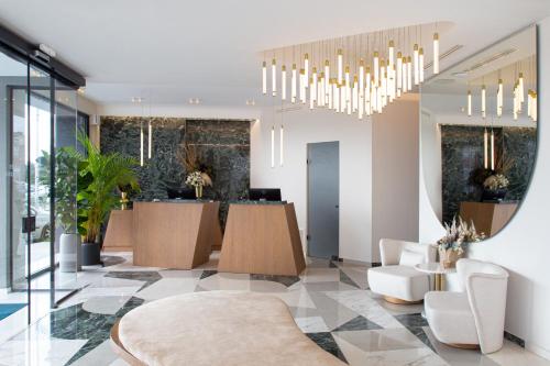 a lobby with a waiting room with chandeliers at 1910 Lifestyle Hotel in Volos