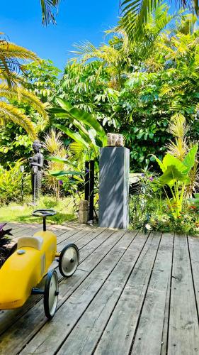 a yellow toy car sitting on a wooden deck at Île tropical lodges in Sainte-Anne