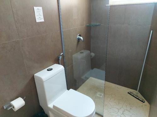 アラカティにあるVILAS NA PRAIA RESIDENCE O PARAÍSO É AQUIのバスルーム(トイレ、ガラス張りのシャワー付)