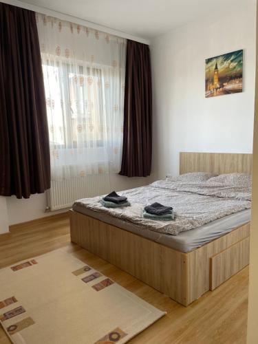 a bedroom with a bed and a large window at Class Park Residence in Târgovişte