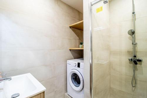 ein Badezimmer mit einer Waschmaschine und einem Waschbecken in der Unterkunft ZenBNB / Sandy / Parking privé / 5 pers. / Géant / in Annemasse