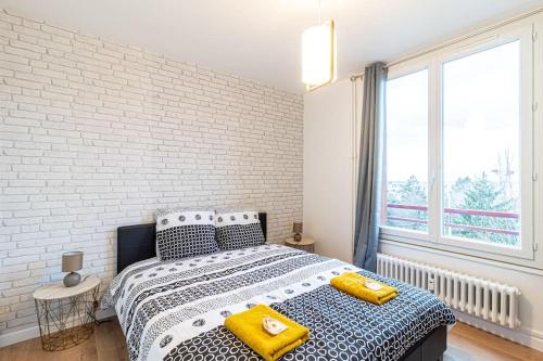 Un dormitorio con una cama con almohadas amarillas. en ZenBNB / Sandy / Parking privé / 5 pers. / Géant /, en Annemasse