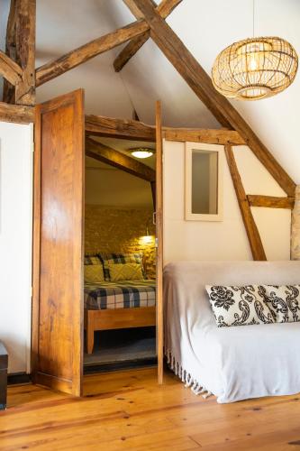 - une chambre avec un lit dans une pièce dotée de poutres apparentes dans l'établissement Château La Barge - Dordogne, à La Boissière-dʼAns