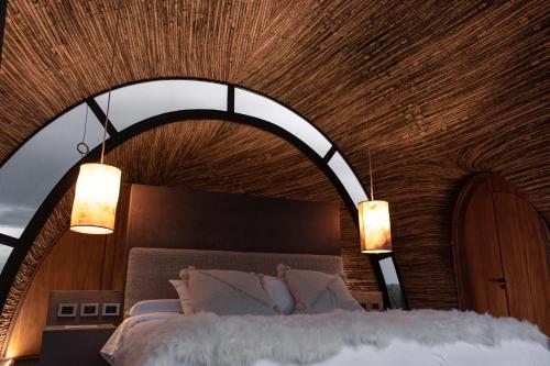 a bedroom with a large bed with a wooden ceiling at Chozos Resort in Agrelo