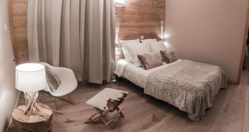 een slaapkamer met een bed, een stoel en een lamp bij Hotel Les Flocons in Les Deux Alpes