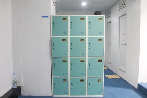 a locker room with green lockers in a room at Bu Sepuh GuestHouse in Sangkanurip