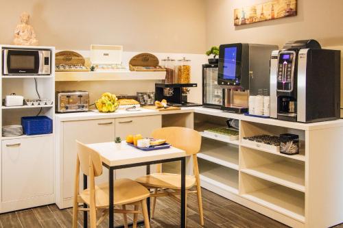 uma cozinha com uma mesa e alguns micro-ondas em Twenty Business Flats Maisons Alfort Les Juilliottes em Maisons-Alfort