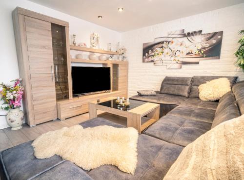 ein Wohnzimmer mit einem Sofa und einem Flachbild-TV in der Unterkunft TRUTH für 5 - King Size Betten, Kamin, Garten, XXL Couch, Smart-TV in Dortmund