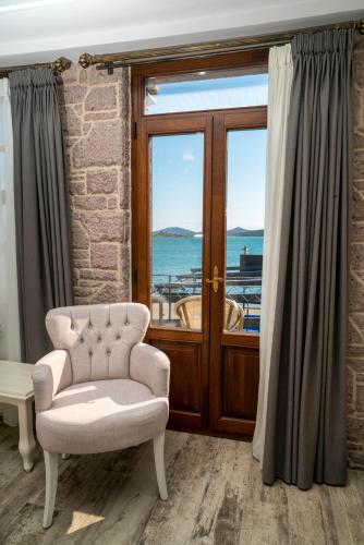 a living room with a chair and a window at Cunda Taka in Ayvalık