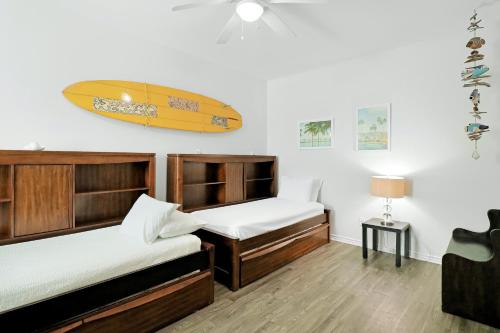 a room with two beds and a surfboard on the wall at Nemo Cay - Endless Summer I in Padre Island