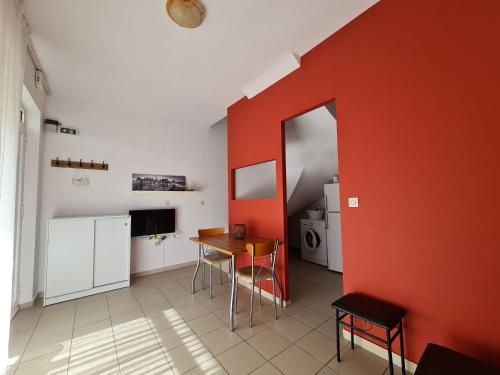 a room with a table and a red wall at alexandros apartment in Kavála