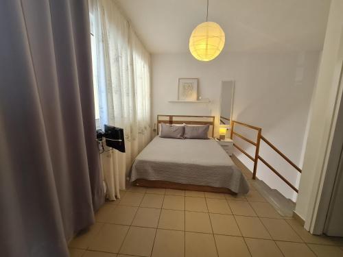 a small bedroom with a bed and a window at alexandros apartment in Kavála