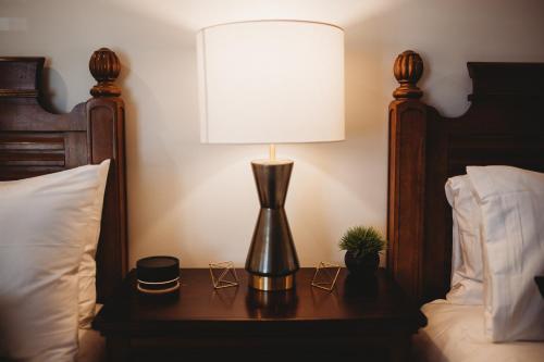 a lamp on a table next to a bed at The Jefferson Inn in Southern Pines