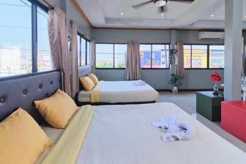 Bkk39 Airport hotel في Ban Khlong Prawet: سريرين في غرفة بها نوافذ