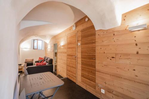 Cette chambre dispose de murs en bois, d'une table et d'un canapé. dans l'établissement Aya, appartement moderne dans le cœur du village, au Monêtier-les-Bains