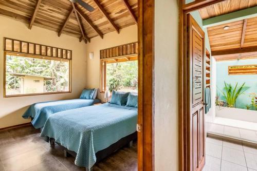 1 dormitorio con 2 camas y ventana en Casa Corazón - Premium Vacation Home, en Puerto Viejo
