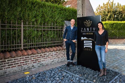 a man and a woman standing next to a sign at SN Logies in Tremelo