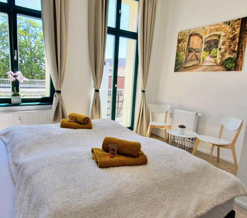 ein Schlafzimmer mit einem Bett mit zwei braunen Handtüchern darauf in der Unterkunft "HOGULU" Brandenburg, Im Herzen der Altstadt, Stilvoll, Küche in Brandenburg an der Havel