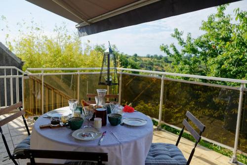 une table avec un chiffon de table blanc sur un balcon dans l'établissement Les chambres de la Vallée, à Argenton-Château