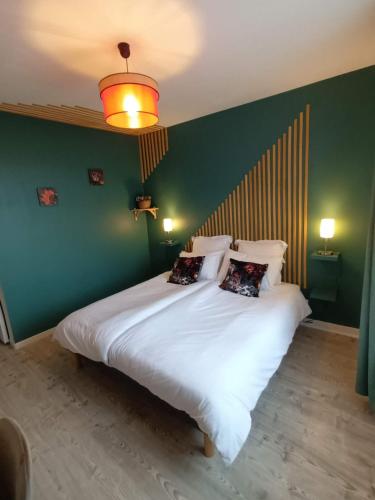 Les chambres de la Vallée في Argenton-Château: غرفة نوم بسرير ابيض كبير وبجدار اخضر
