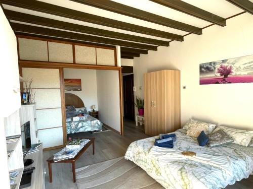 een woonkamer met een bed en een bank bij Casa Anna - Parco Hermitage in Porto Valtravaglia