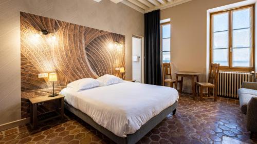 Habitación de hotel con cama grande y sofá en Logis Hostellerie Bressane, en Saint-Germain-du-Bois