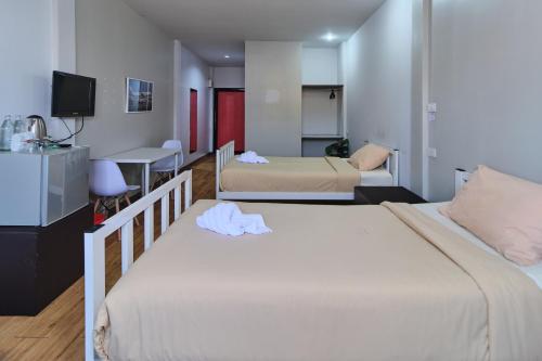 a hotel room with two beds and a television at Bkk39 Airport hotel in Ban Khlong Prawet