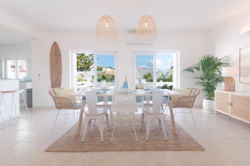 a white dining room with a table and chairs at Villa Sound of the Sea by Portugal Collection in Aljezur