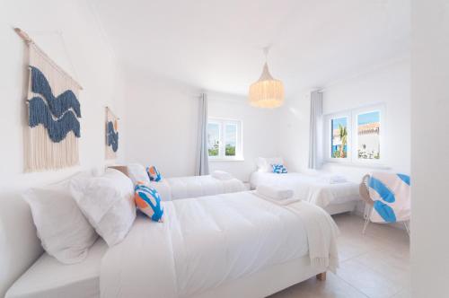 a white room with two beds and a couch at Villa Sound of the Sea by Portugal Collection in Aljezur