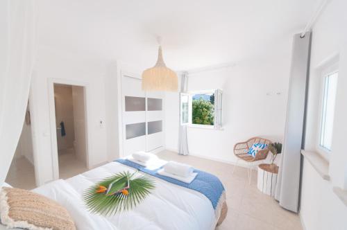 a white bedroom with a bed with a palm tree on it at Villa Sound of the Sea by Portugal Collection in Aljezur