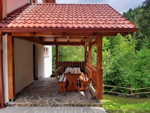 - un kiosque en bois avec un banc sur la terrasse dans l'établissement Apartma Ribnica na Pohorju, à Ribnica na Pohorju