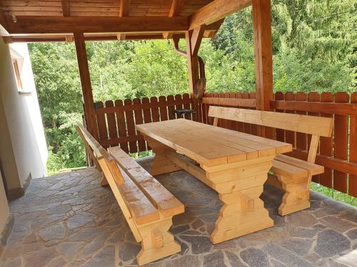 einem Picknicktisch aus Holz und einer Bank auf einer Terrasse in der Unterkunft Apartma Ribnica na Pohorju in Ribnica na Pohorju