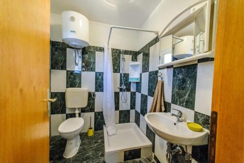 La salle de bains est pourvue de toilettes et d'un lavabo. dans l'établissement Apartments & rooms Lucie, à Posedarje