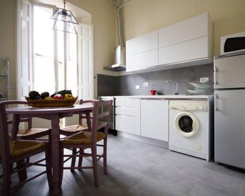 a kitchen with a table and a washing machine at Appartamento del Bobolino in Florence