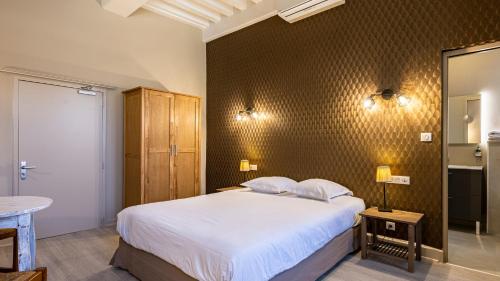 Ένα ή περισσότερα κρεβάτια σε δωμάτιο στο Logis Hostellerie Bressane